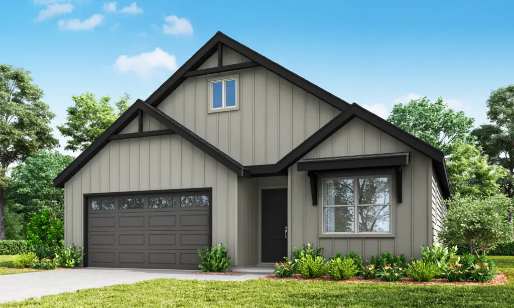 A modern single-story house with gray vertical siding, a dark gray roof, two-car garage, large front window, small porch, and landscaping with green shrubs and grass under a blue sky with scattered clouds.