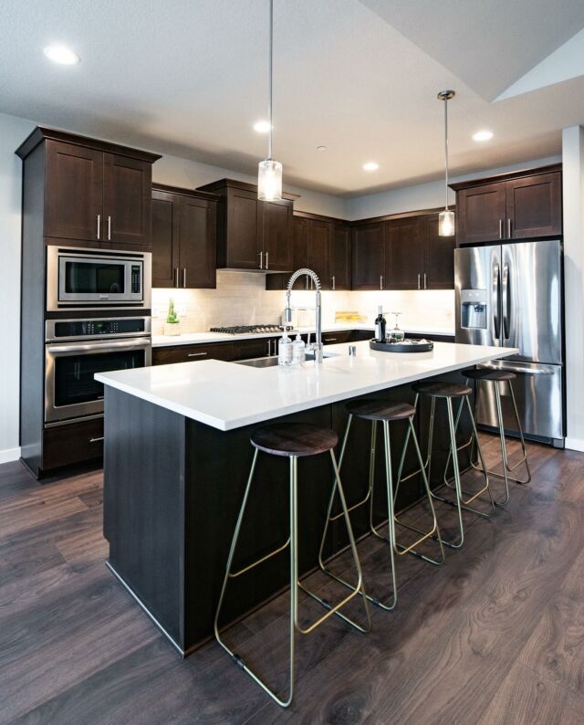 Here's a design take on one of our standard features: stained cabinetry. For a crisp look we chose contrasting white counters and subway tiles with this dark stain option. Contemporary brass barstools add the finishing touch. What do you think? Would you try this look in your kitchen?⁠⁠
⁠⁠⁠